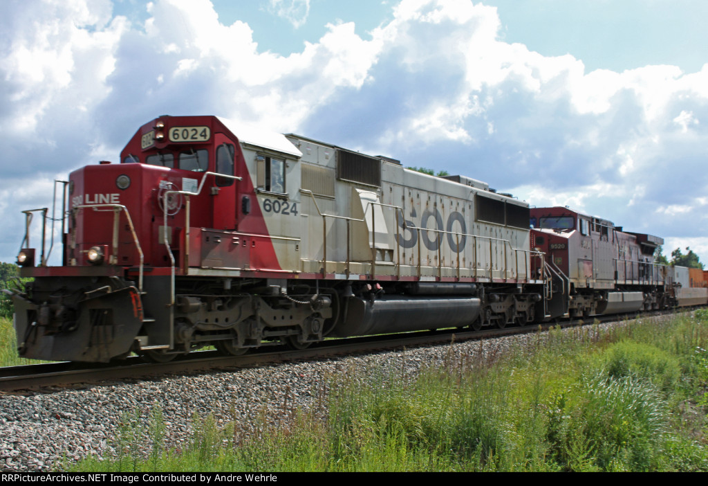 SOO 6024 highballs west on the point of train 199